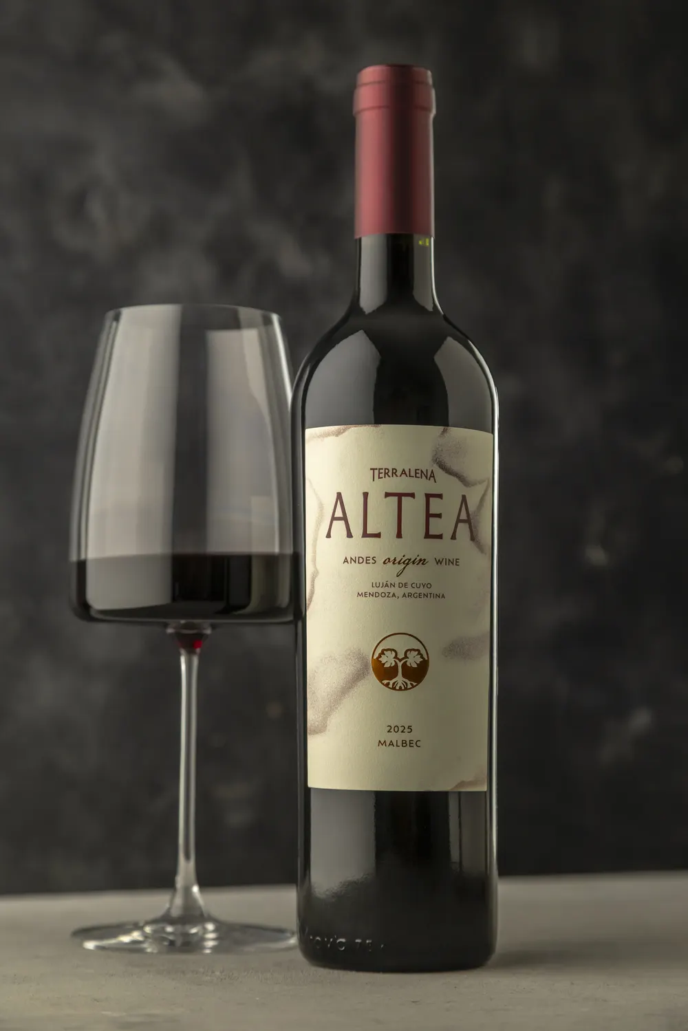 Una botella de Altea Origin junto a una copa servida