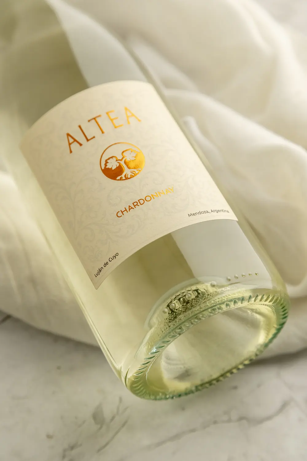 La etiqueta de Altea Chardonnay, con la botella recostada sobre un lino